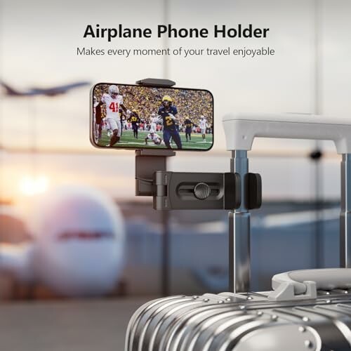 Phone holder attached to suitcase with airplane in background.