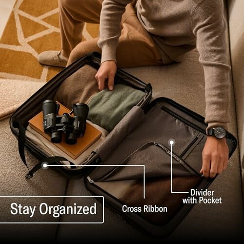 Person organizing luggage with cross ribbon and divider with pocket.