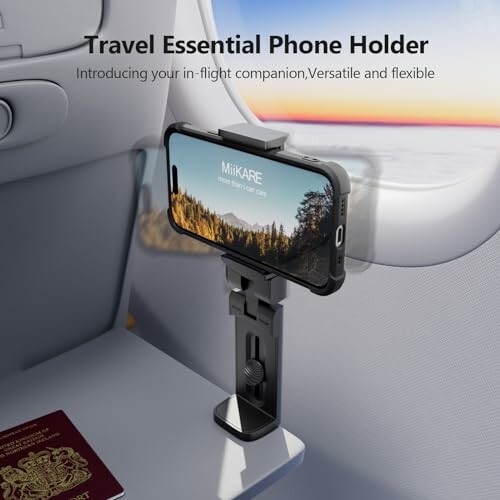 Phone holder attached to airplane tray with phone displaying landscape image.